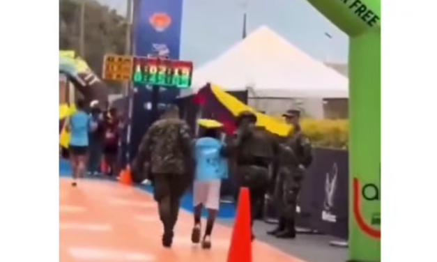 Militar lo toma del brazo y lo lleva a la meta