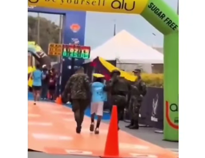 Militar lo toma del brazo y lo lleva a la meta